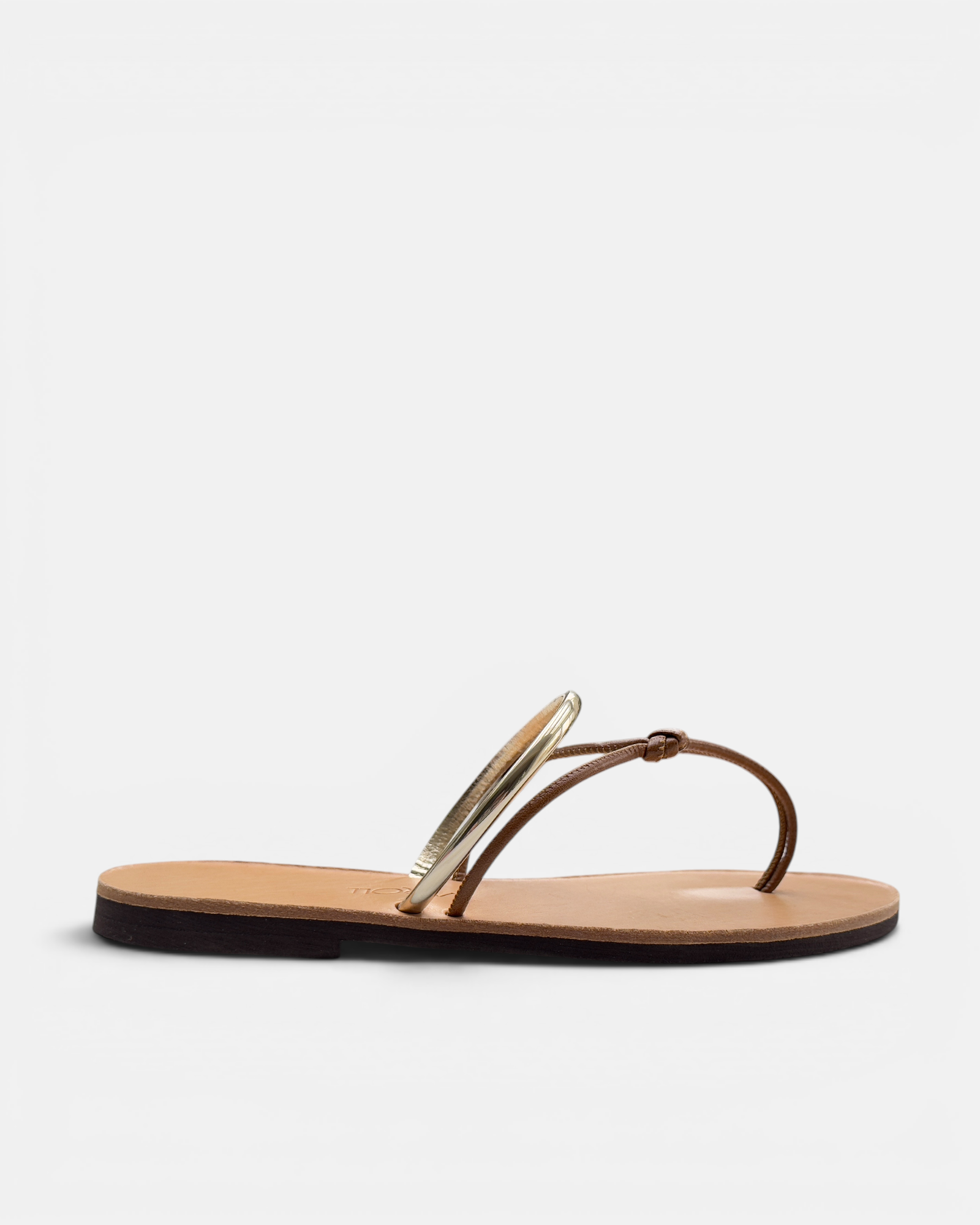Gold sandal with a beige sole on a white background
