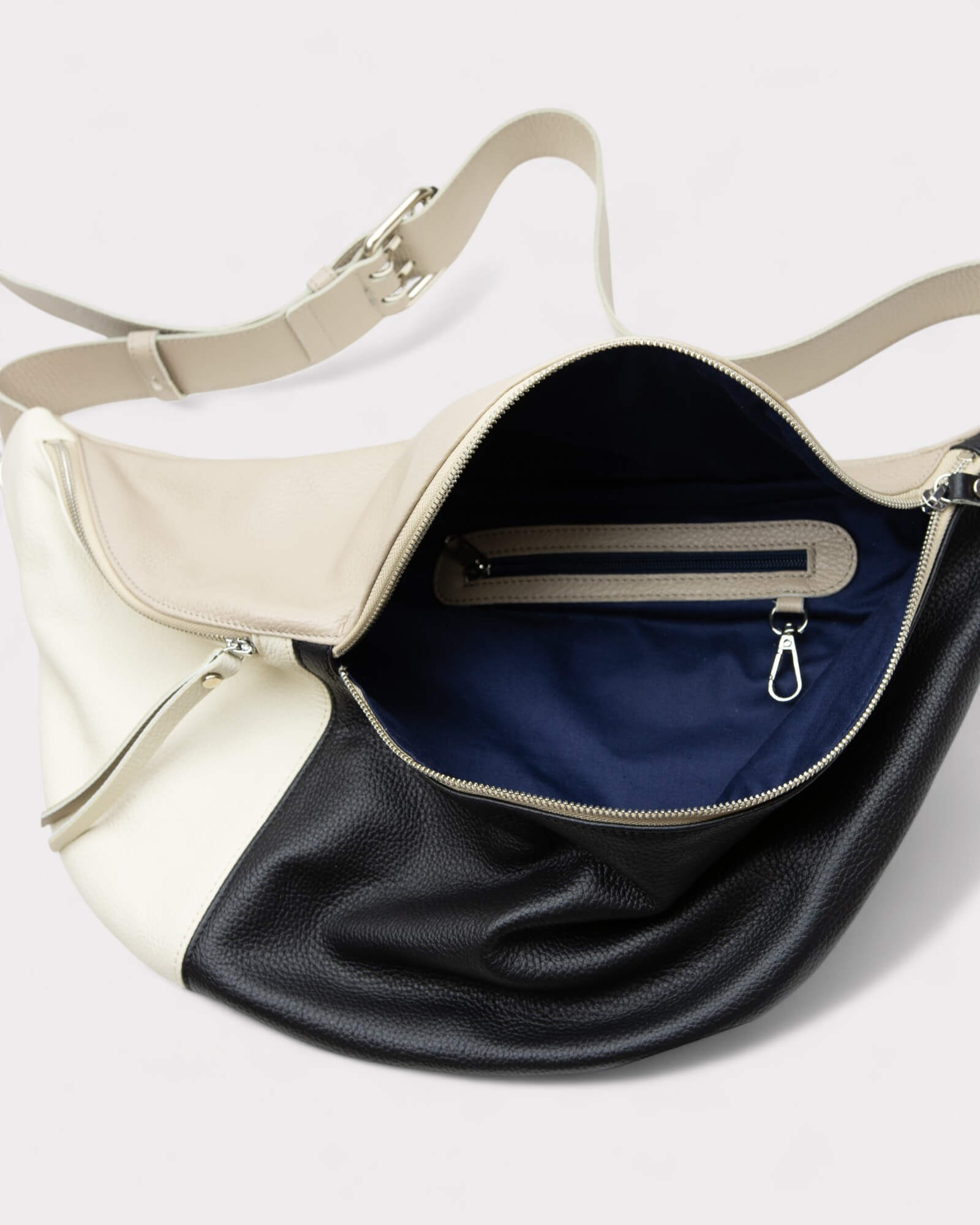 Two-toned leather bag with white and black sections on a light gray background
