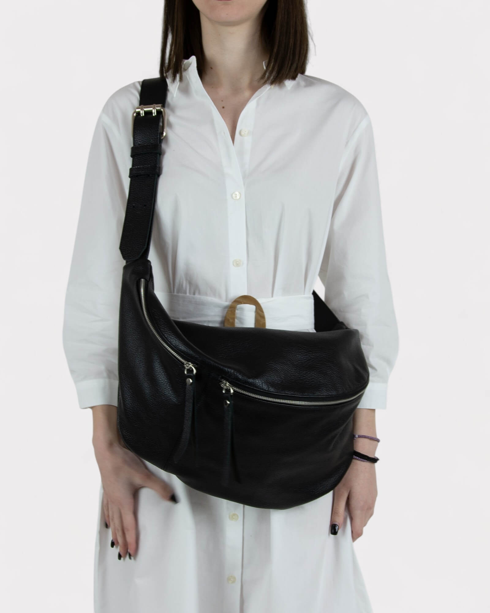Person wearing a black shoulder bag on a white background