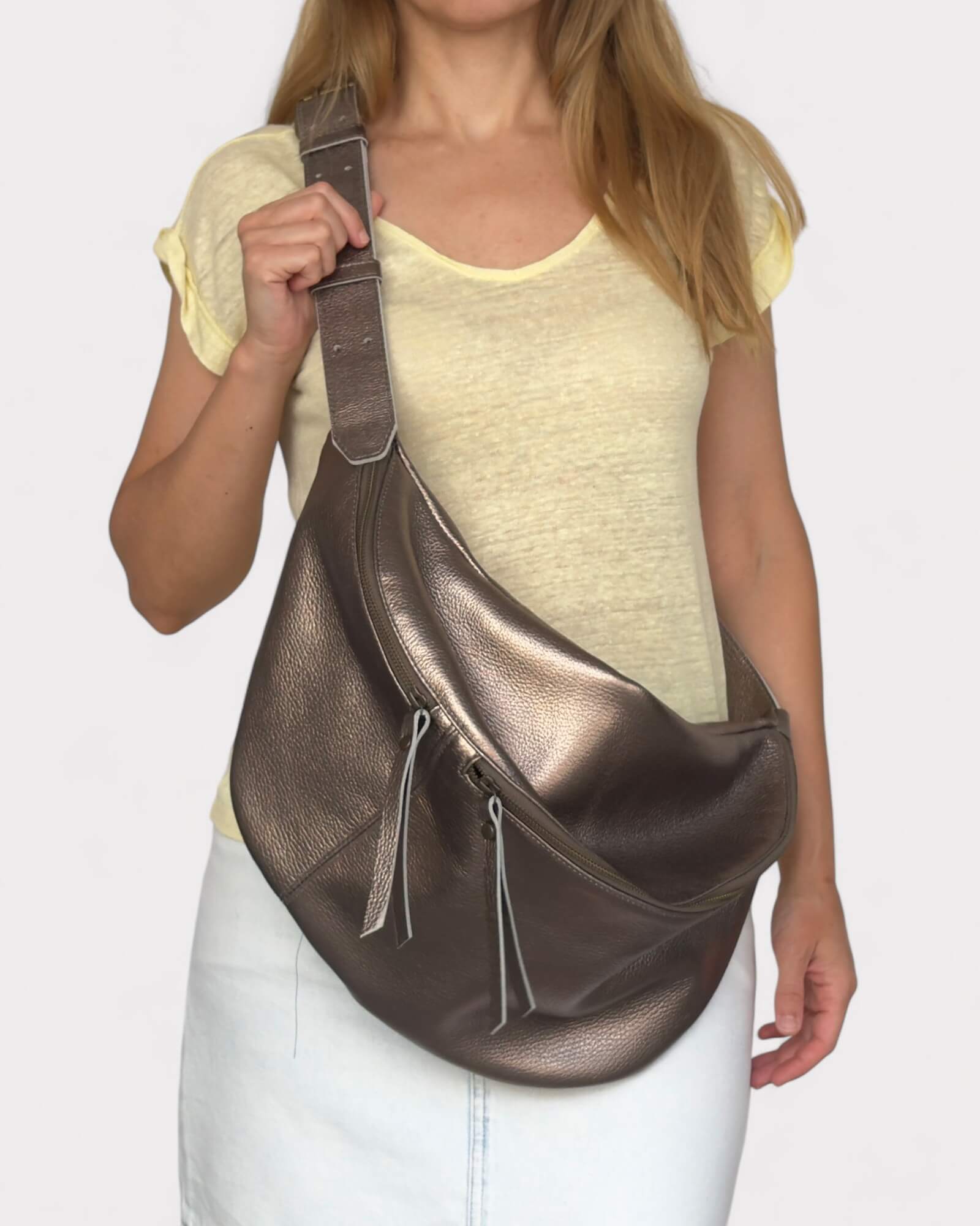 Person wearing a metallic bronze leather chest bag