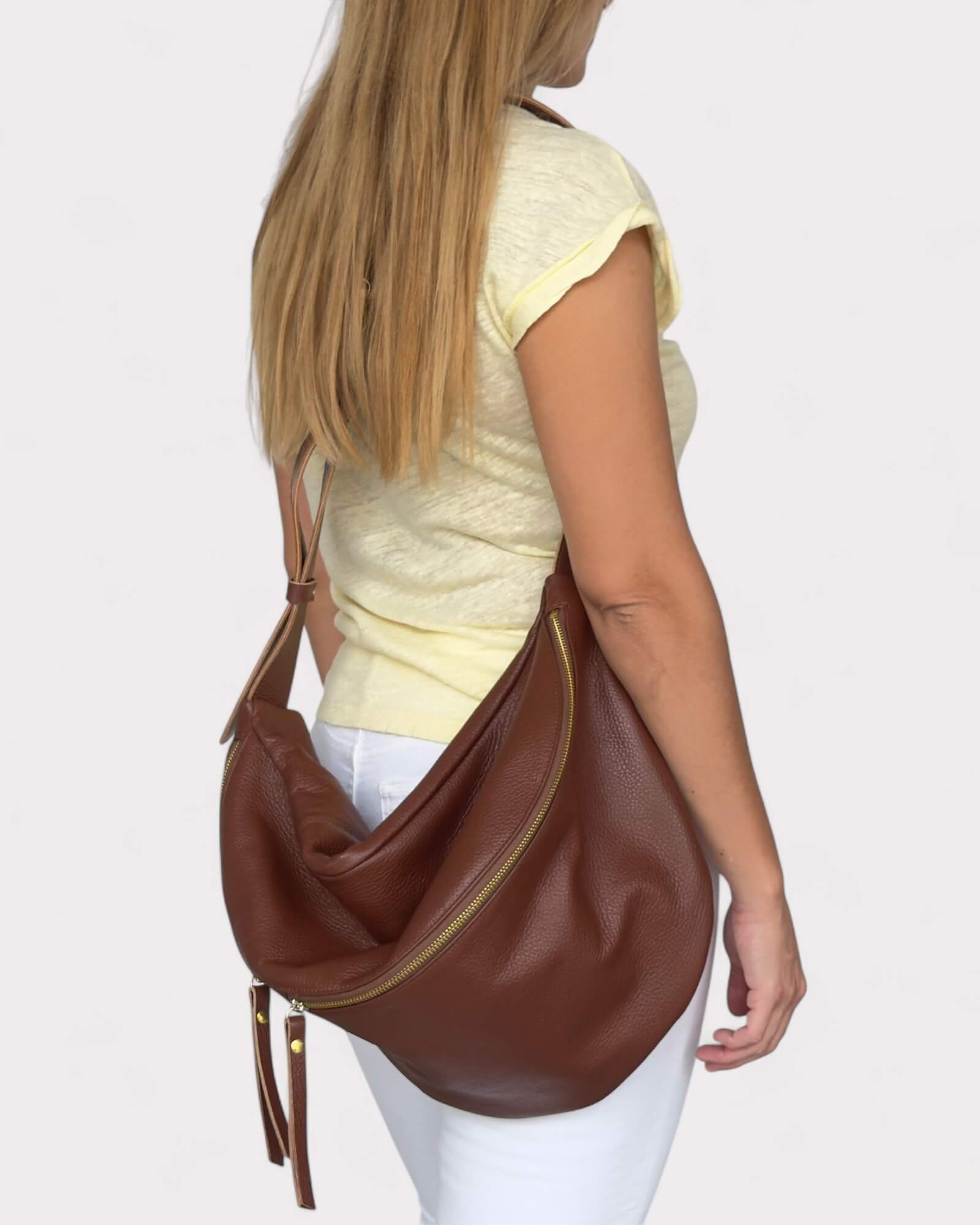 Woman carrying a brown leather fanny pack on a white background