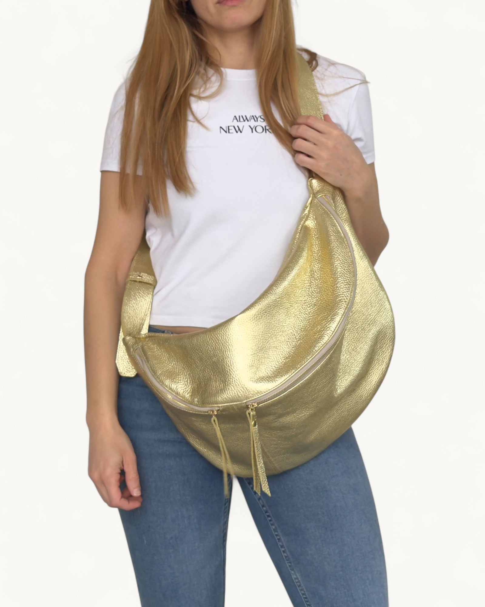 Person holding a gold handbag against a white background