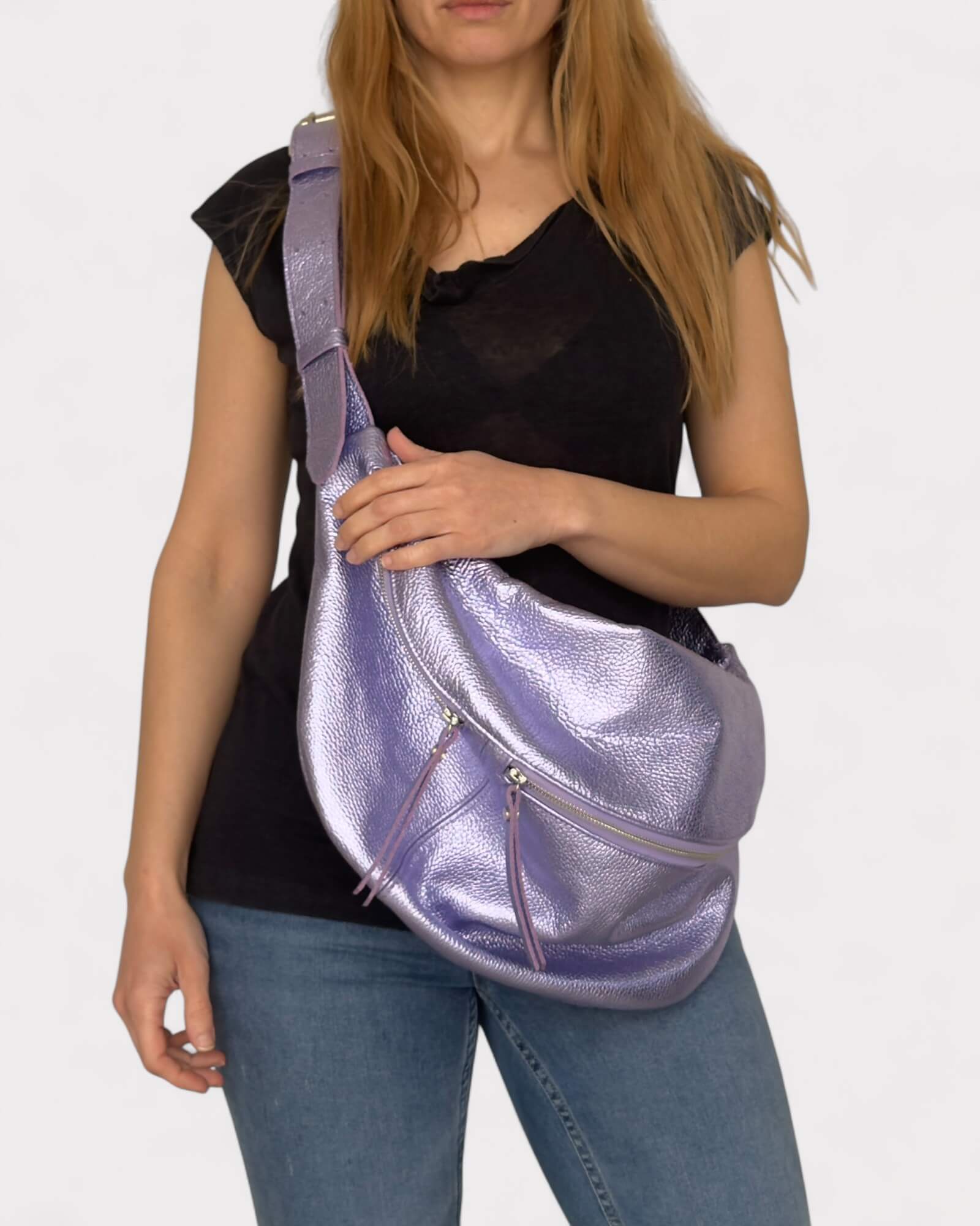 Person holding a purple metallic bag against a plain background