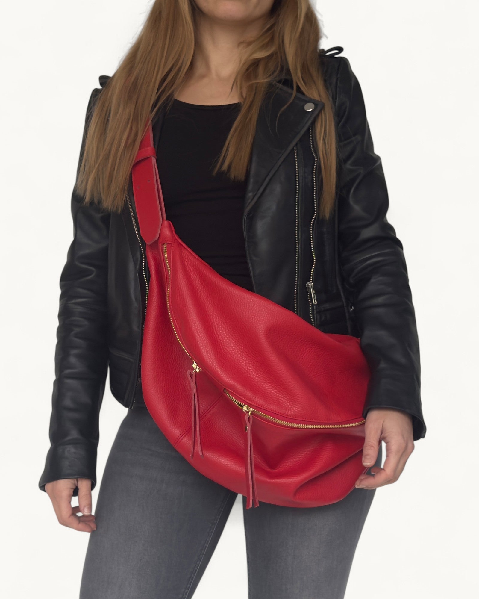 Person wearing a black leather jacket with a red bag over one shoulder on a white background