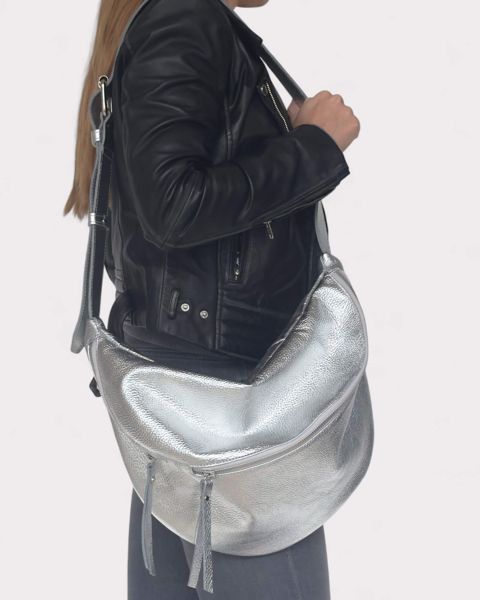 Model holding a silver handbag against a plain background