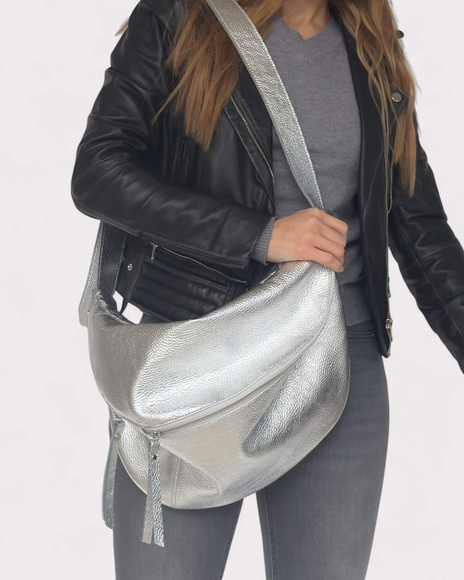 Person holding a silver metallic bag against a white background