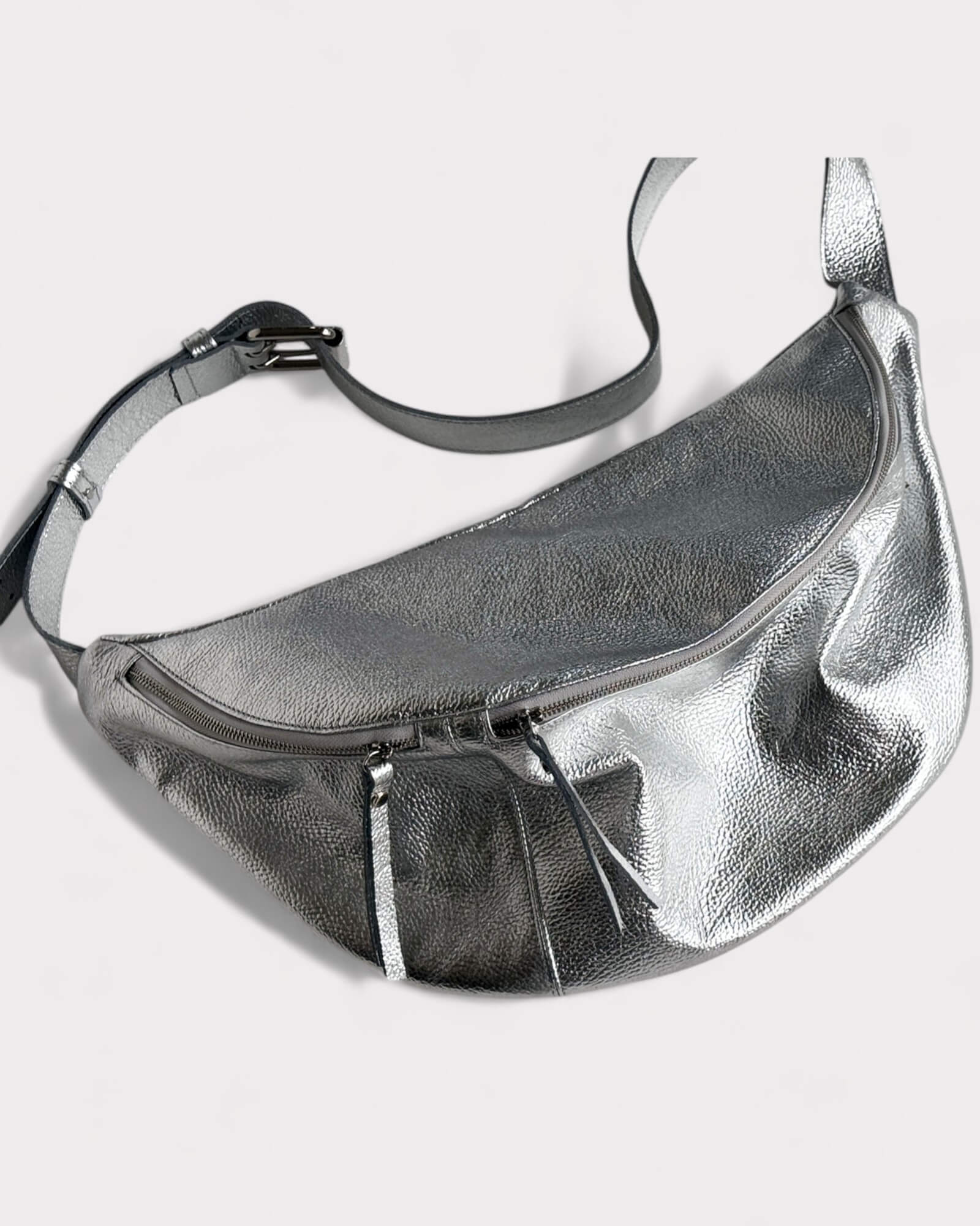 Silver metallic fanny pack on a light gray background
