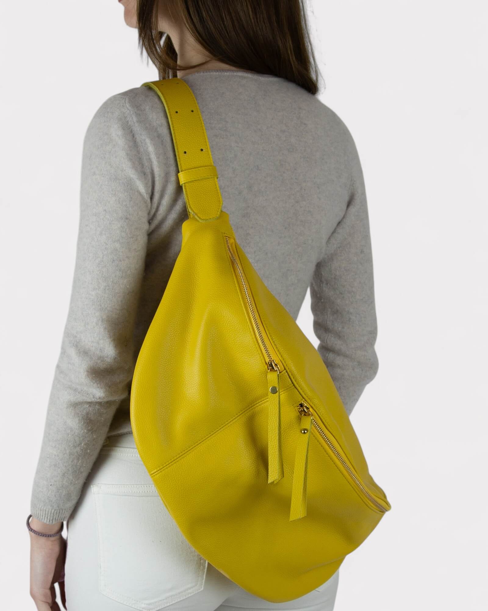 Person wearing a yellow fanny pack on a plain background