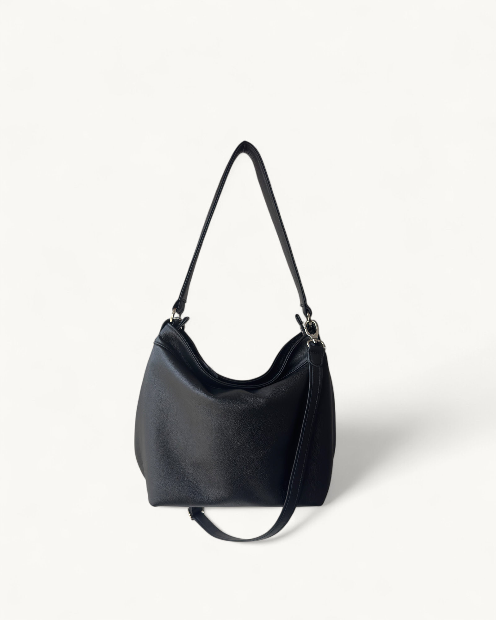Black handbag with a strap on a white background