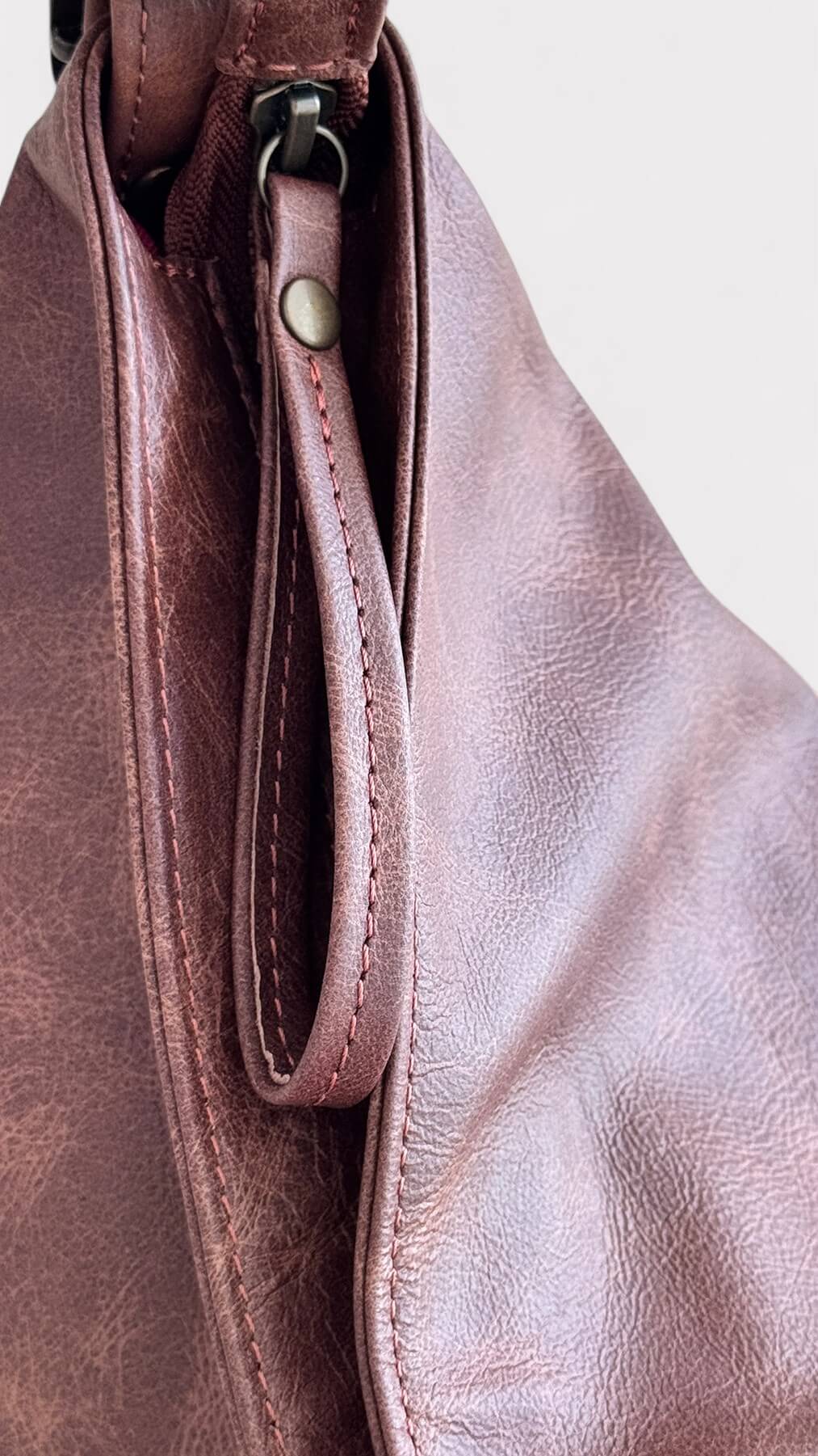 Close-up of a brown leather bag zipper pull