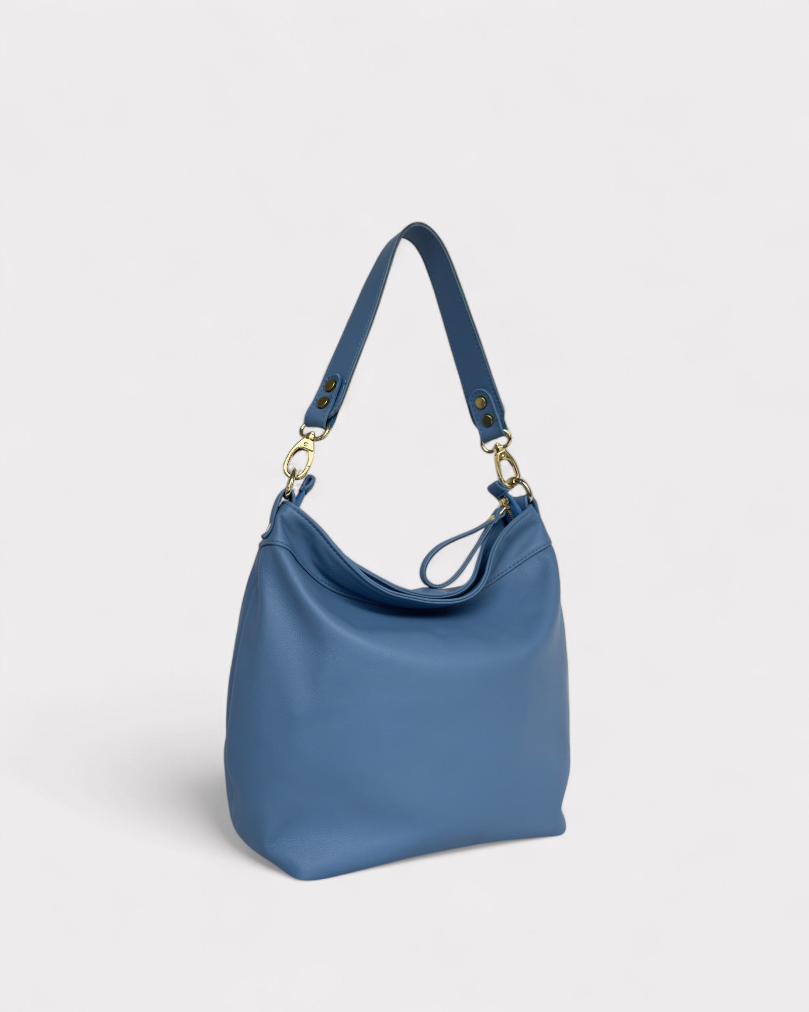 Blue handbag with a strap on a light gray background