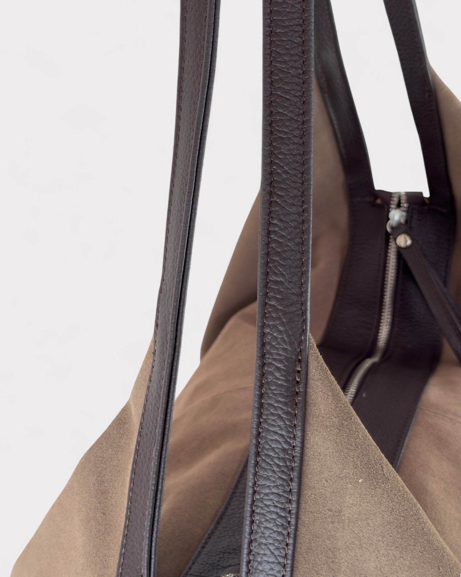 Close-up of handle straps of a taupe handbag