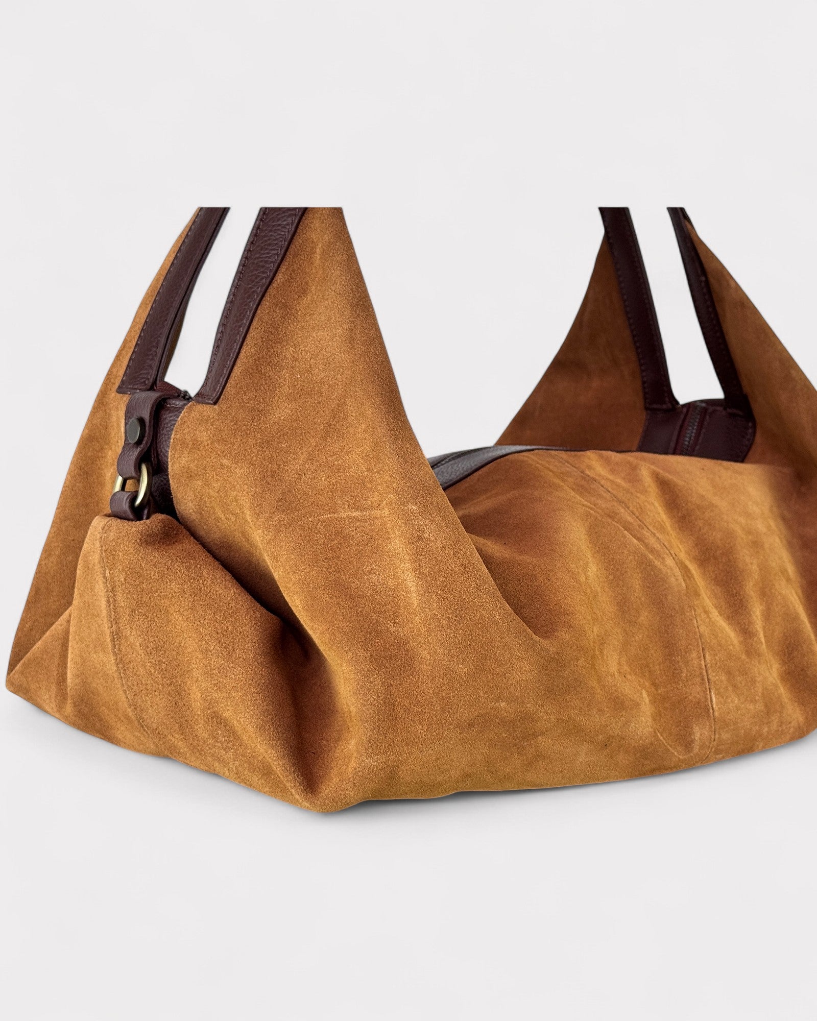 Tan leather handbag with dark brown straps on a light gray background