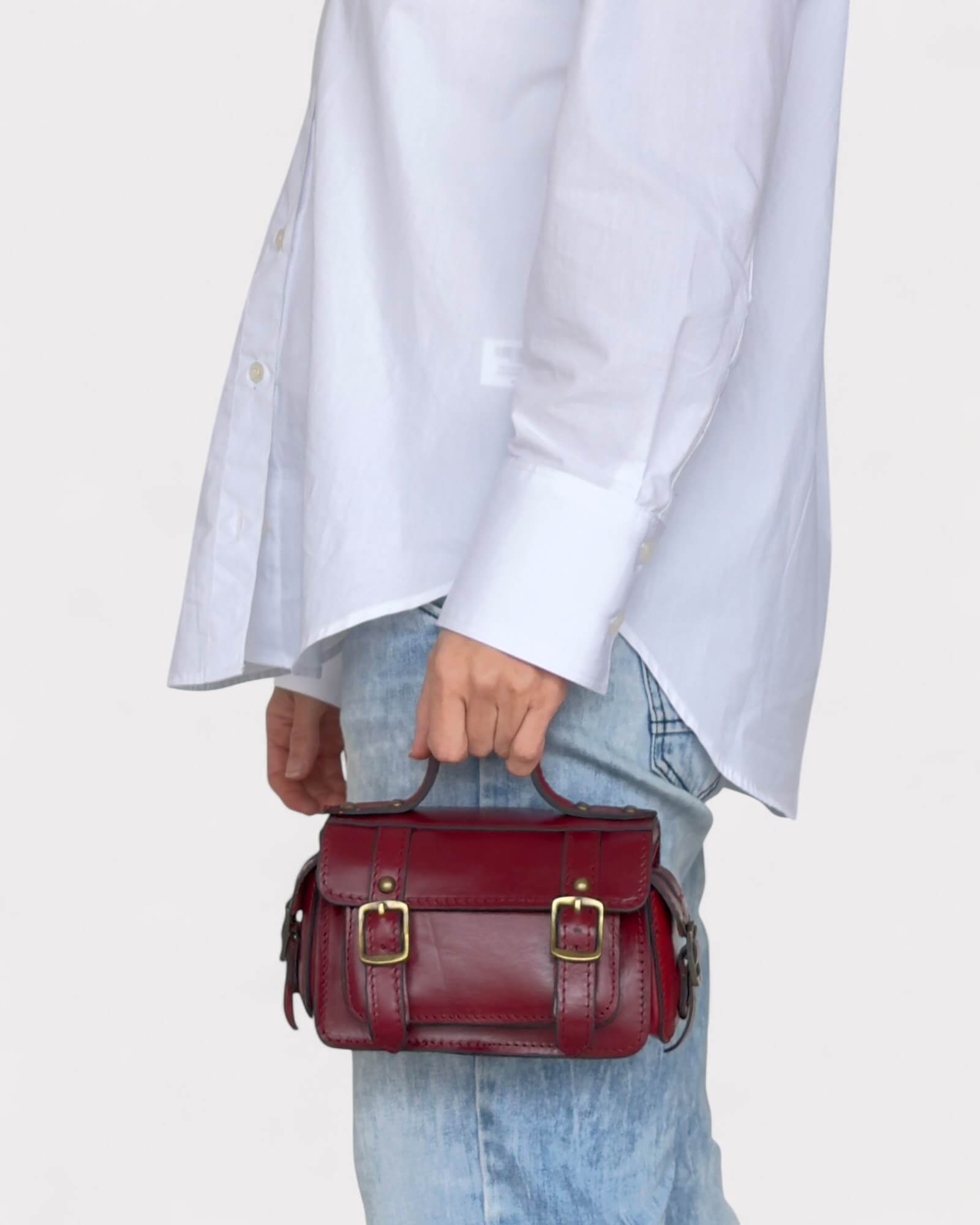 model carrying red crossbody satchel in hands