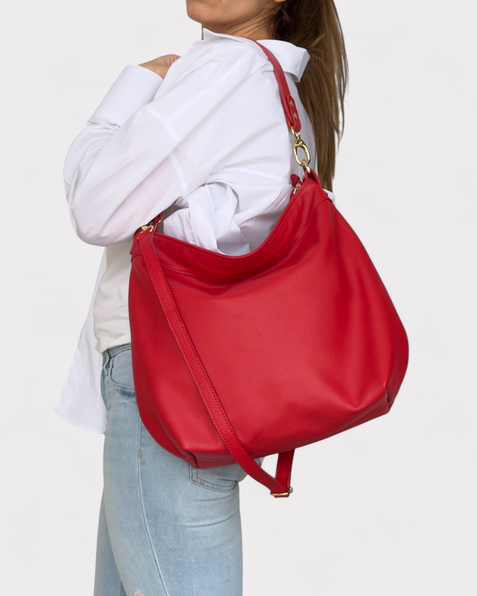 Person wearing a red hobo bag with a plain background