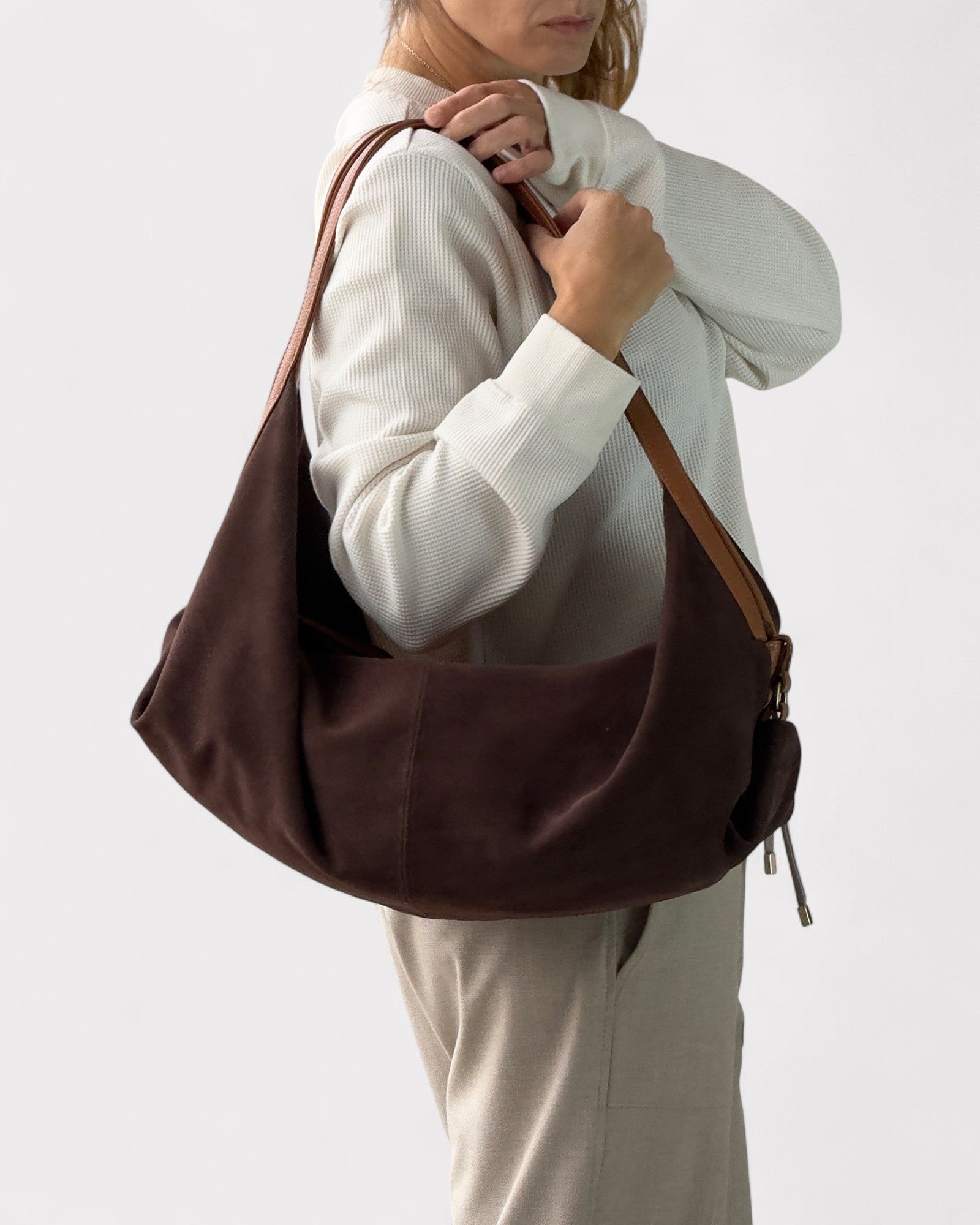 person wearing dark brown suede handbag deluna