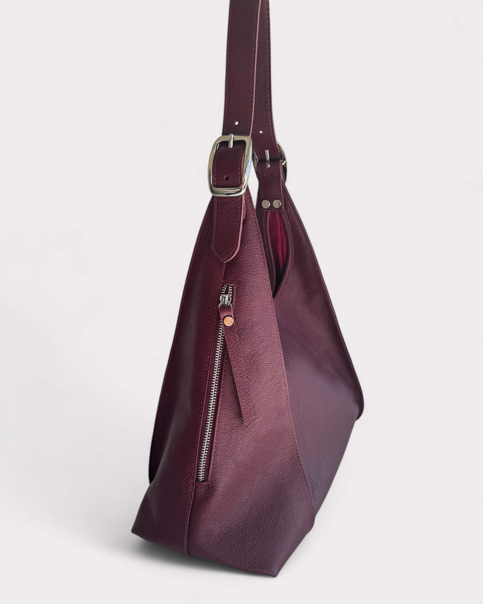 Purple handbag with a strap on a light gray background