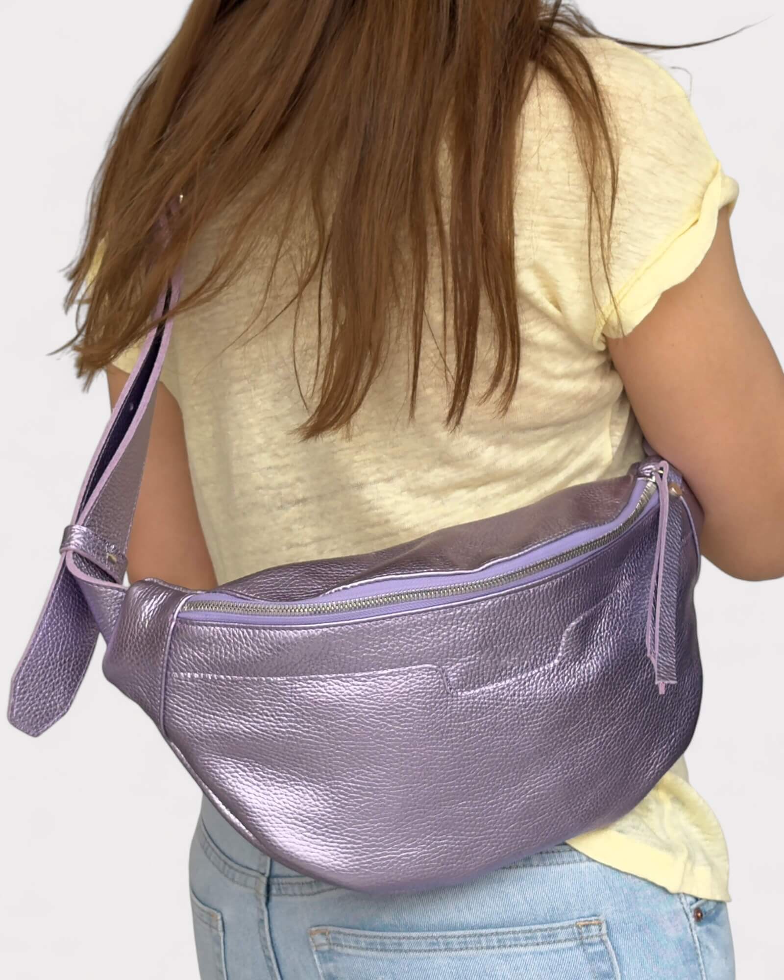 Person wearing a purple fanny pack on a plain background