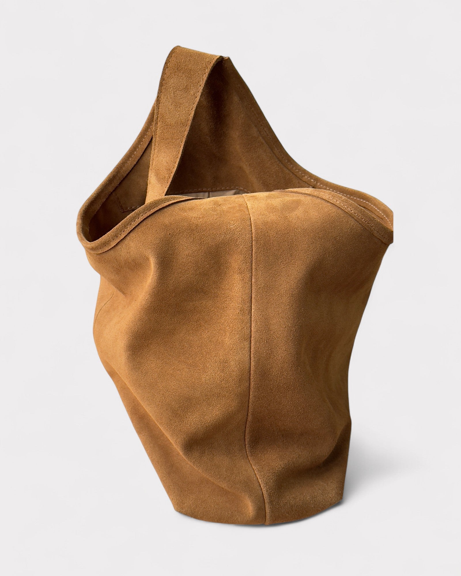 Tan suede handbag on a light gray background