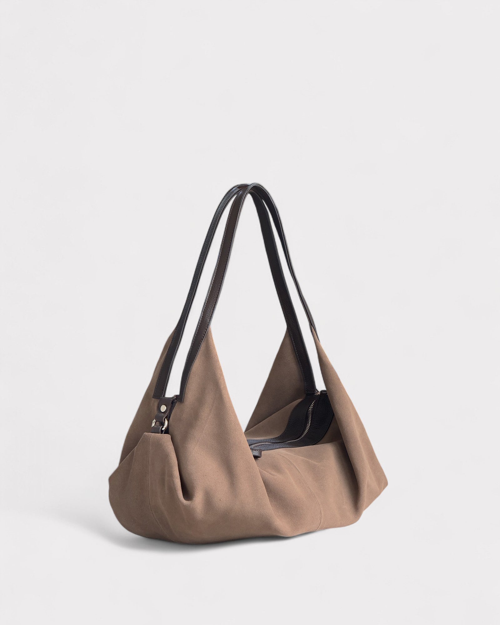 Taupe handbag with black handles on a light gray background