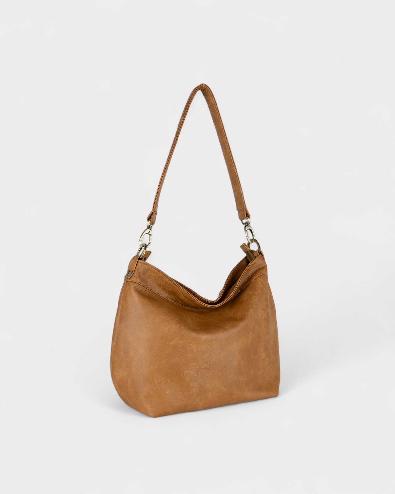 Tan distressed leather handbag with a shoulder strap on a white background