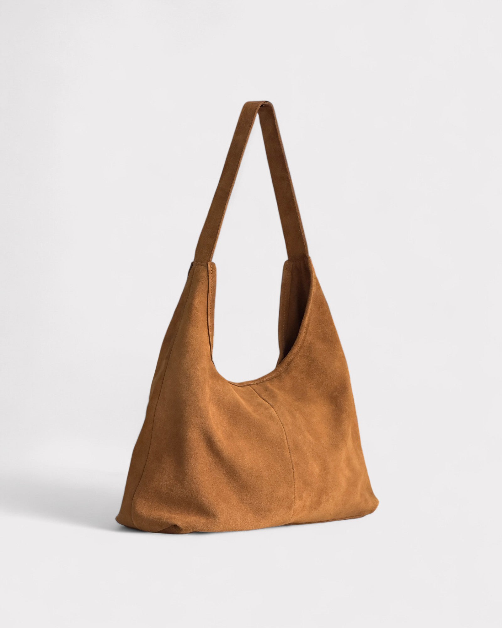 tan suede handbag on a light gray background