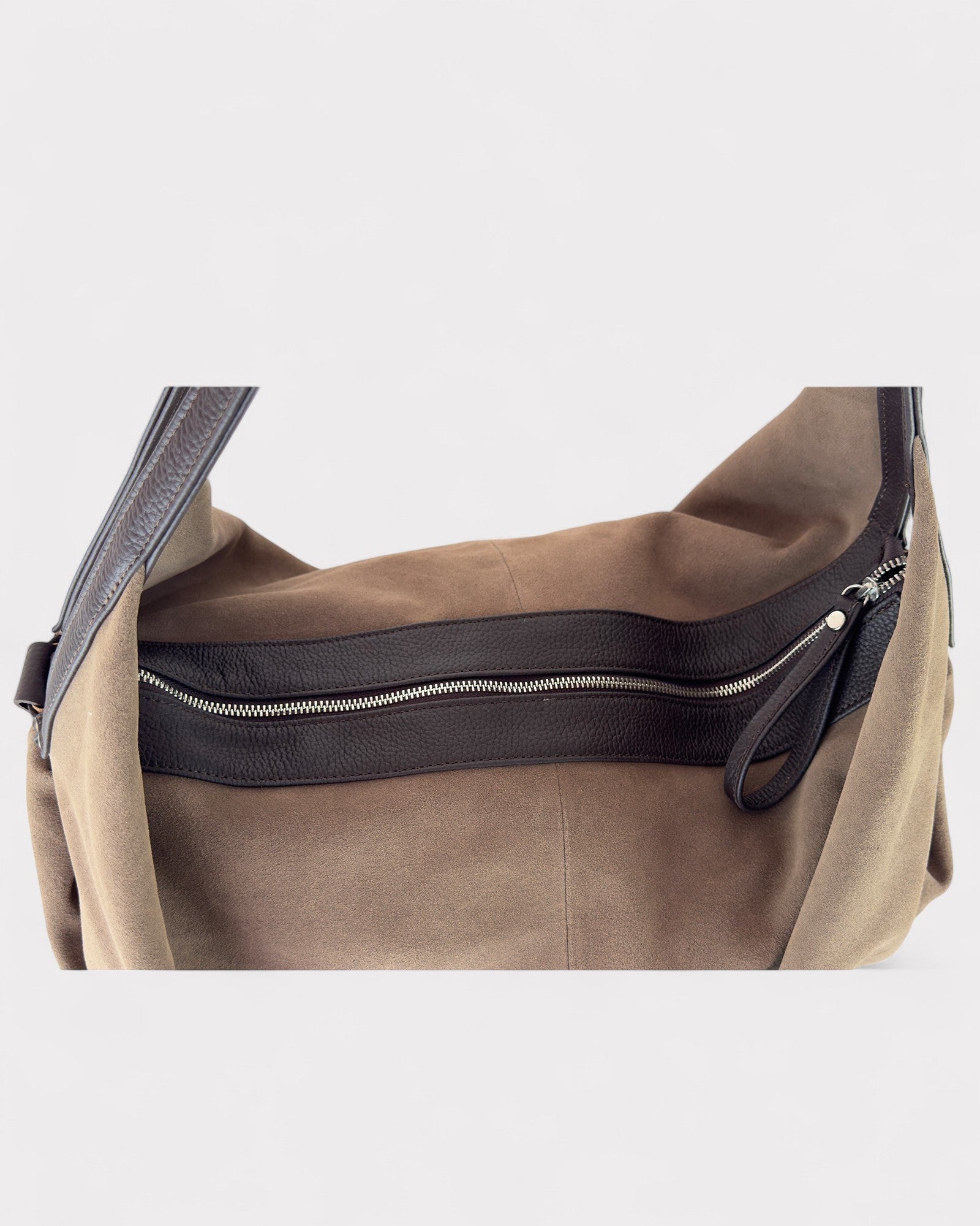 Taupe leather bag with black zipper on a light gray background