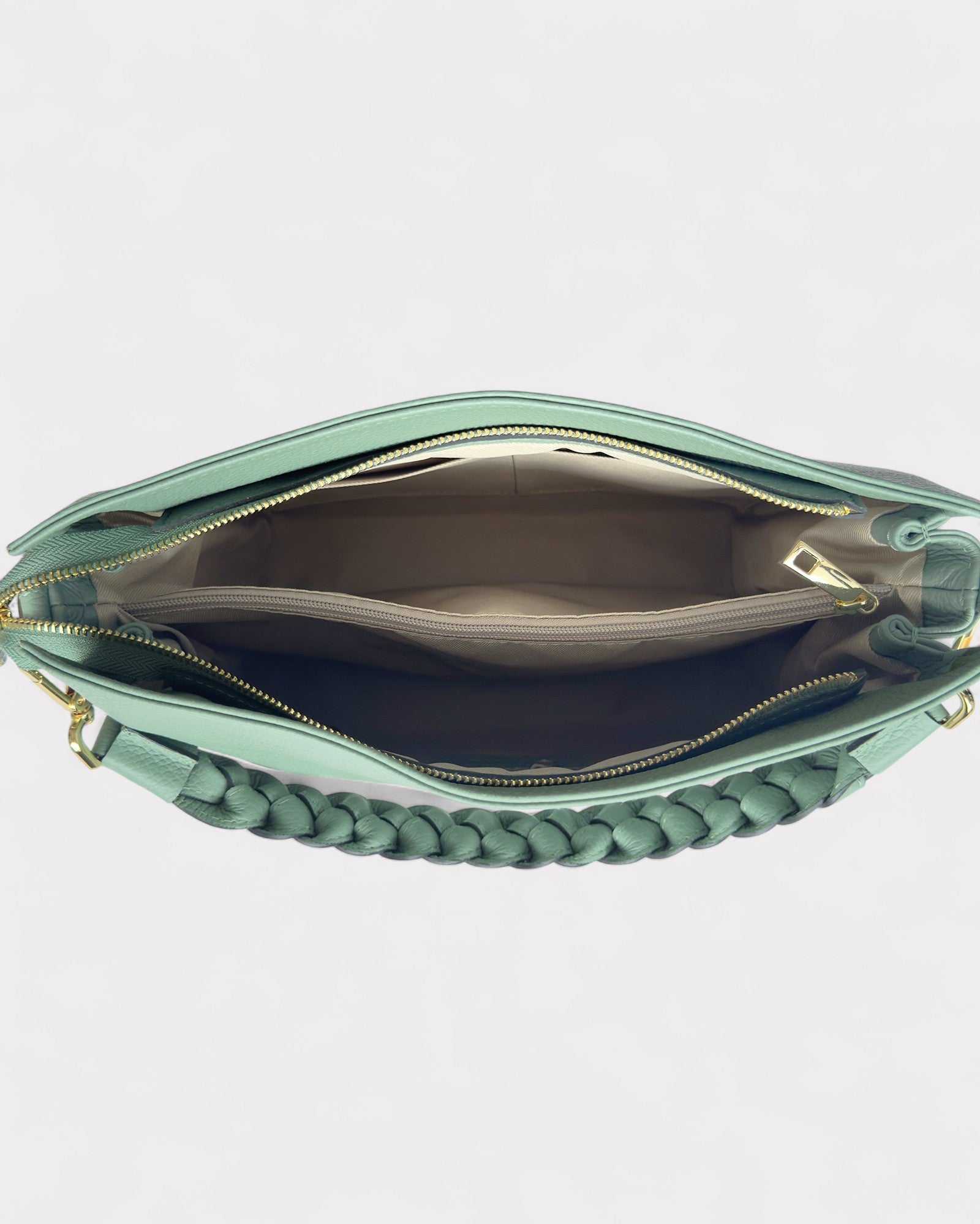 Mint green handbag with braided detail on a light gray background