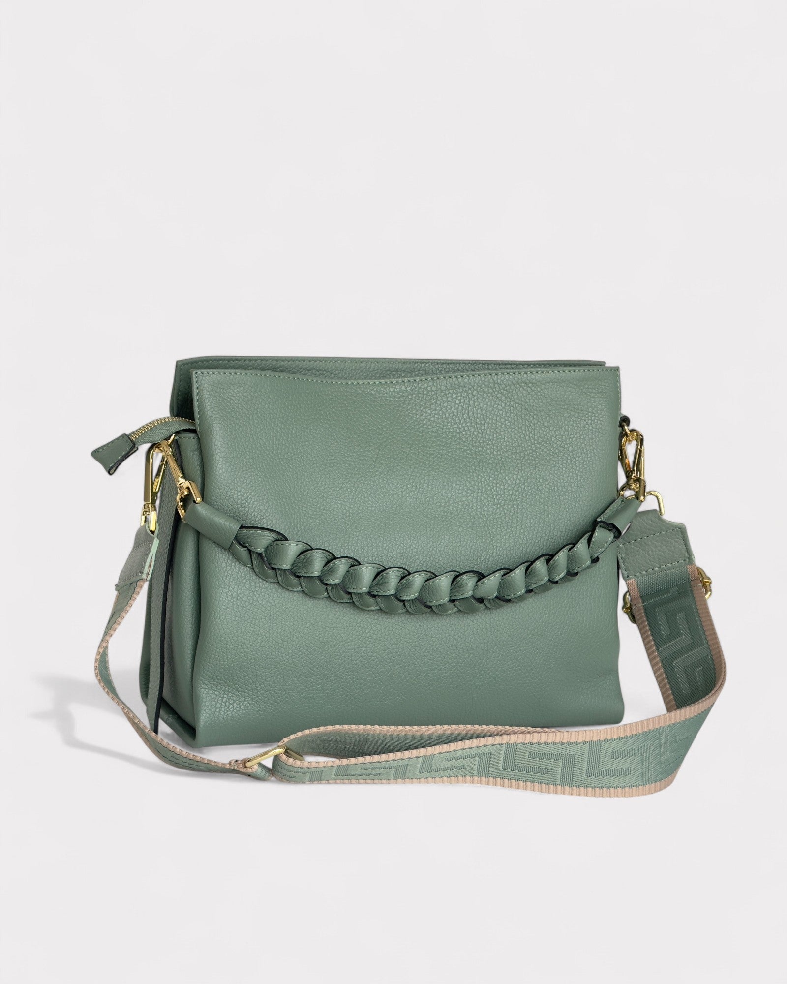 Green handbag with braided strap on a light gray background