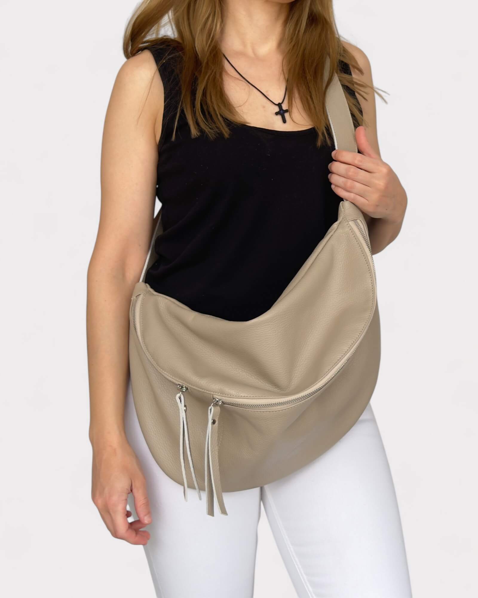 Woman holding a beige fanny pack against a white background