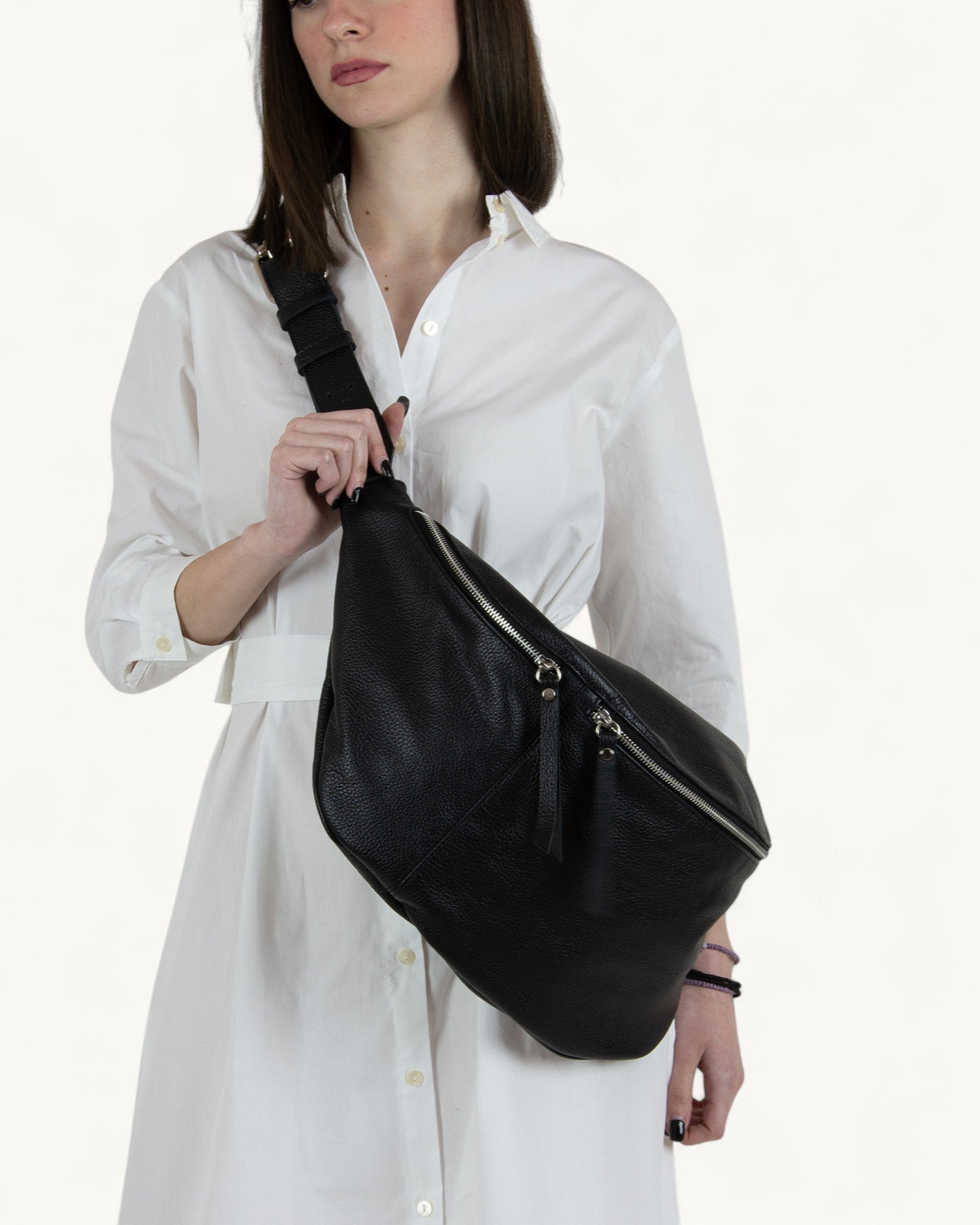 Woman holding a black leather bag against a white background