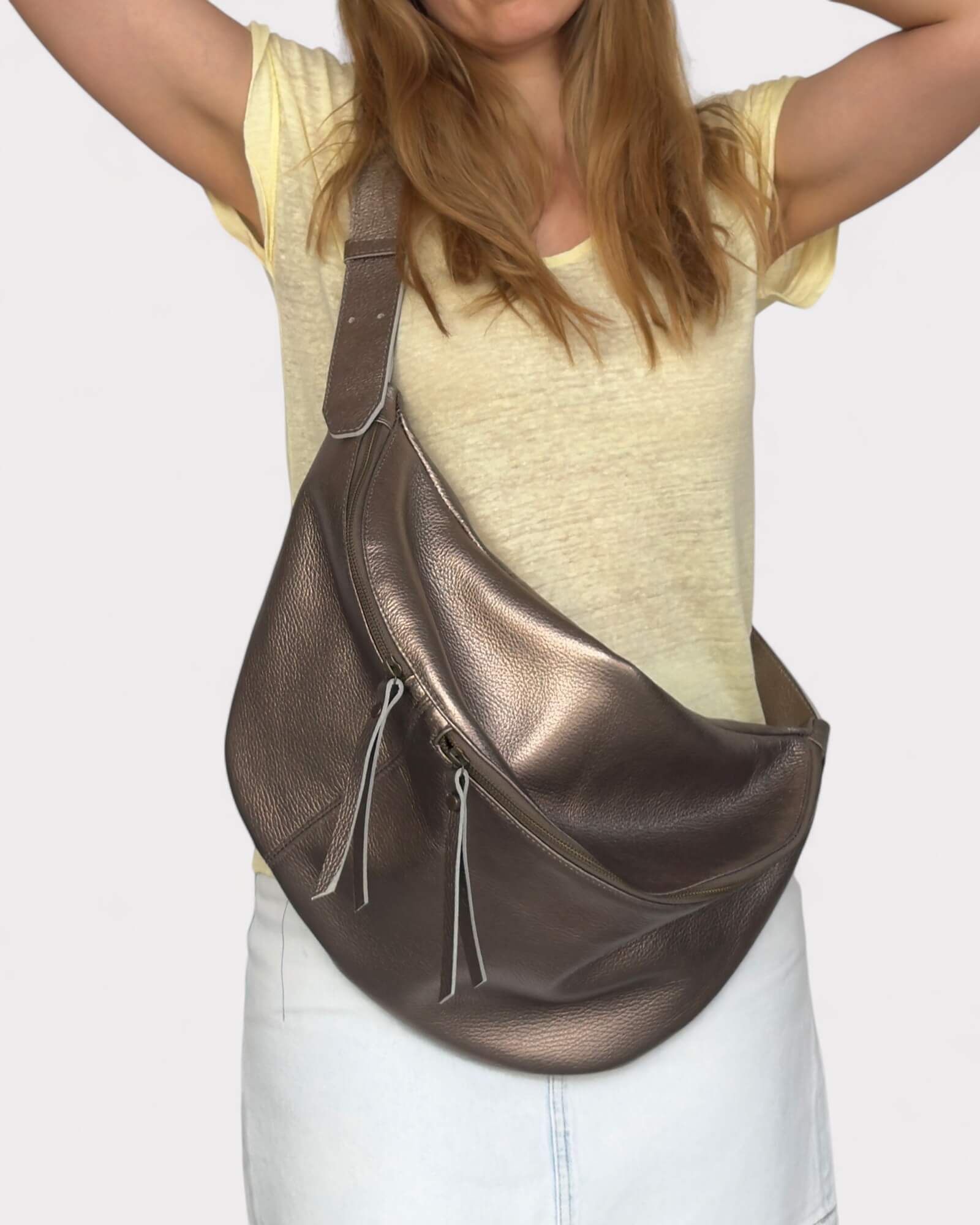 Person wearing a metallic bronze leather bag 