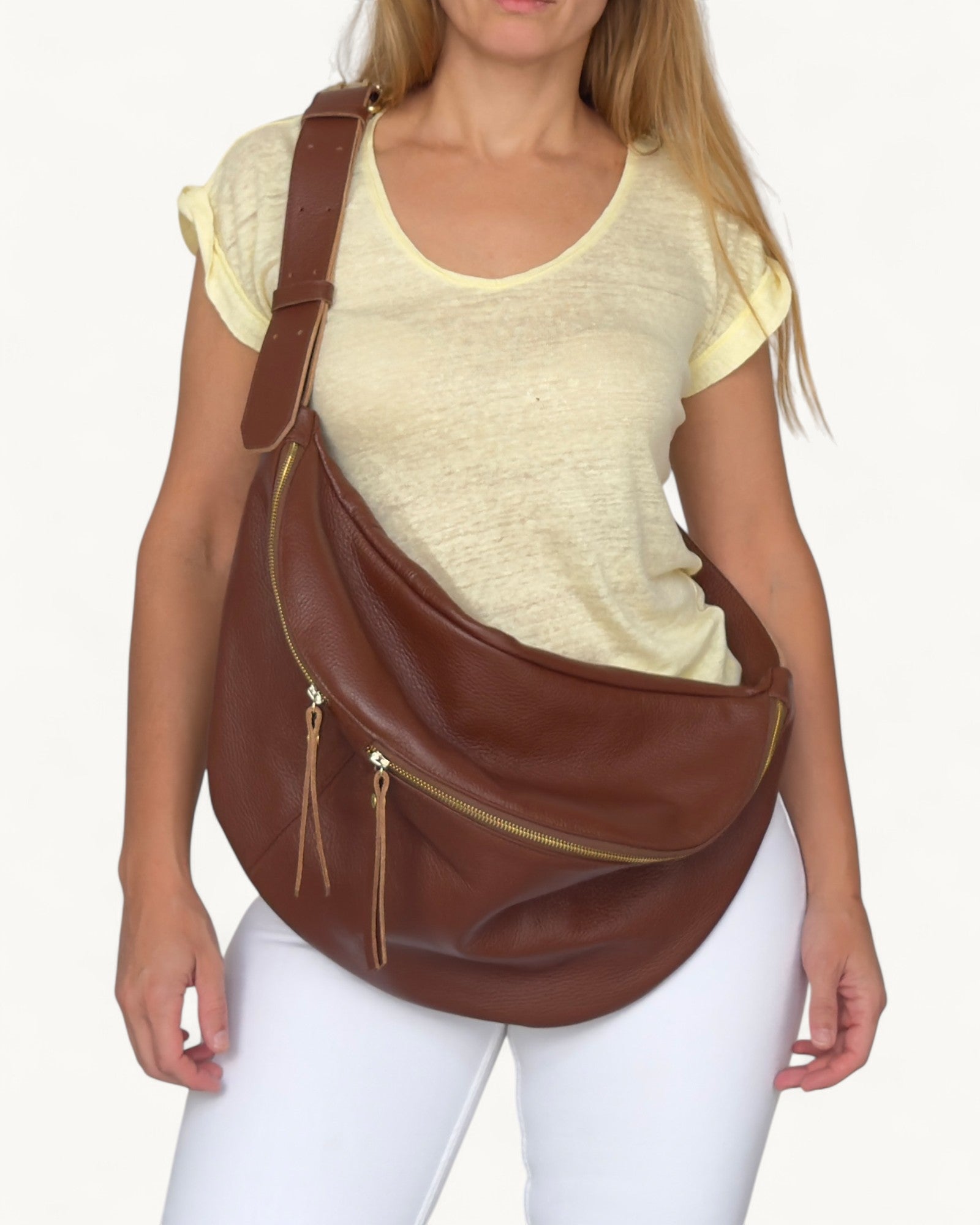 Woman wearing a brown leather shoulder bag on a white background