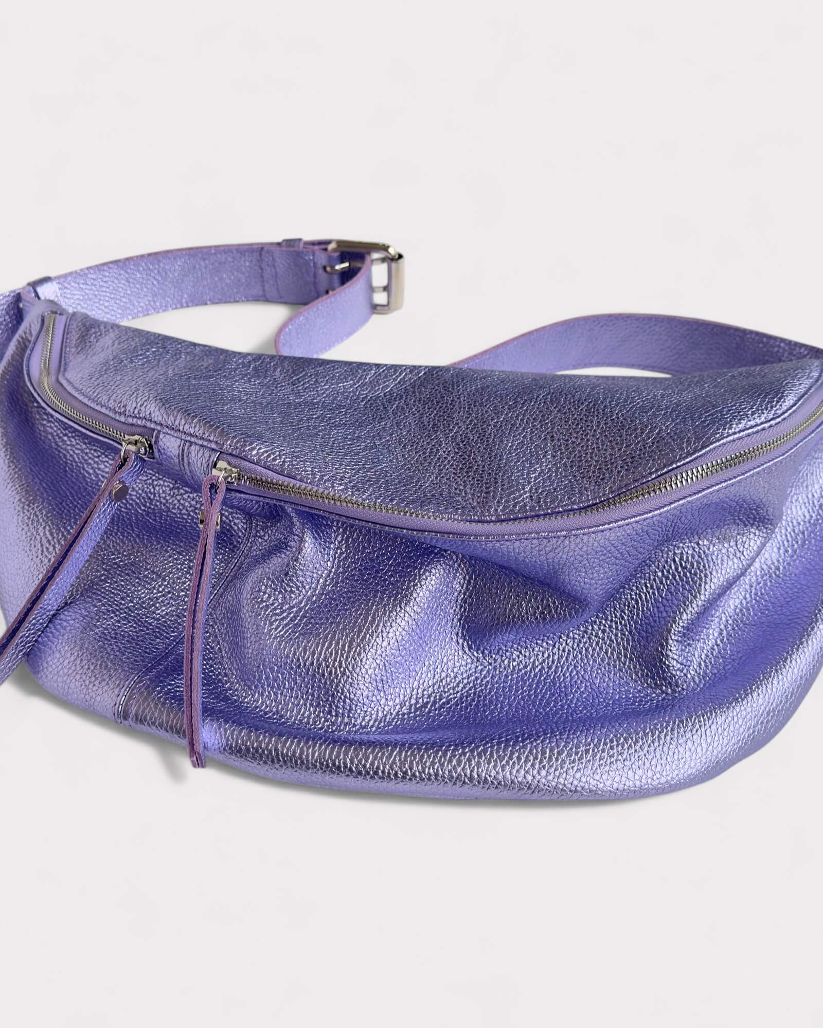 Purple leather waist bag on a light gray background