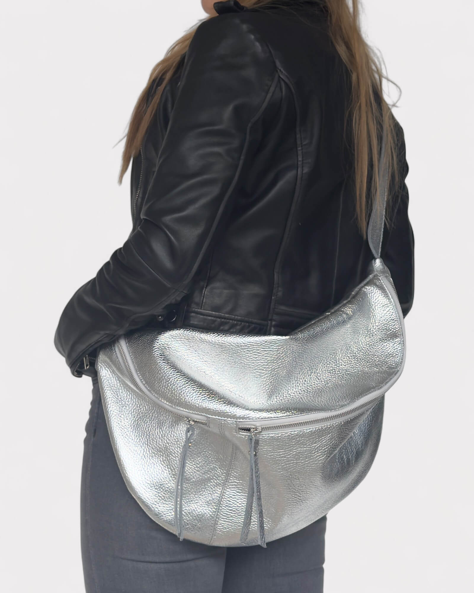 Model wearing a silver fanny pack on a plain background