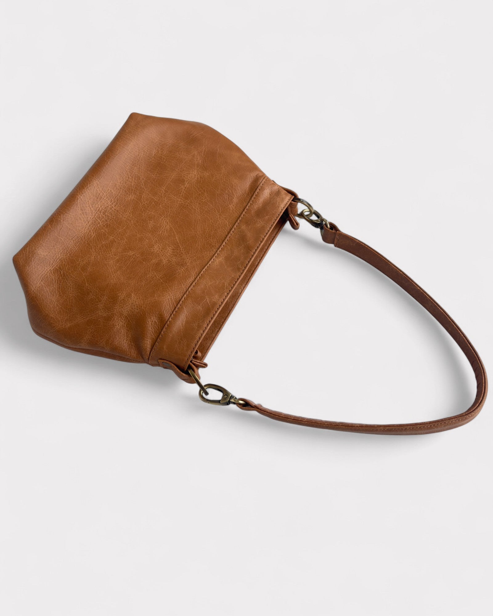 tan distressed  leather handbag on a light gray background