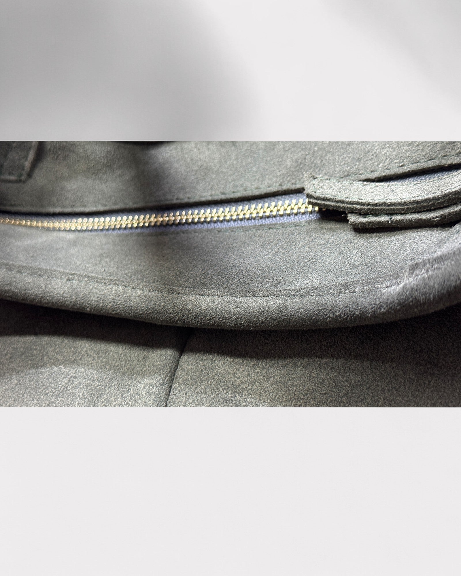 Close-up of a green bag with a zipper on a light gray background