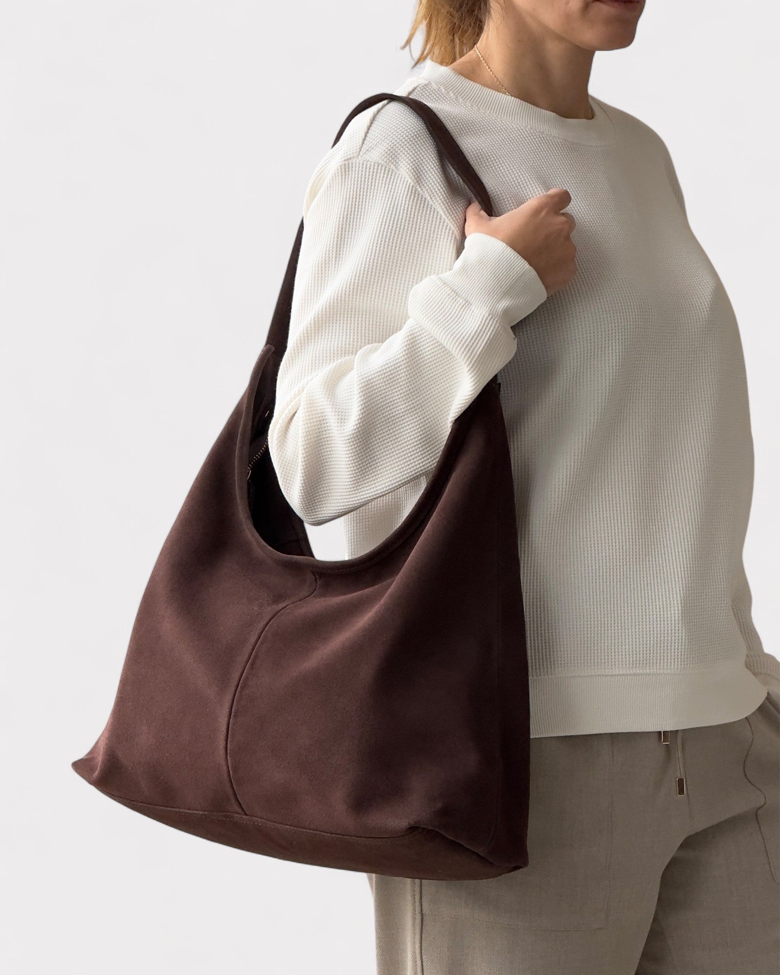 girl wearing dark brown suede handbag
