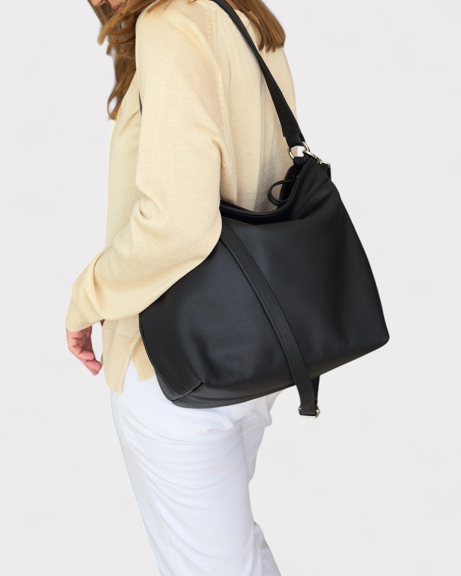 Person wearing a black shoulder bag on a white background