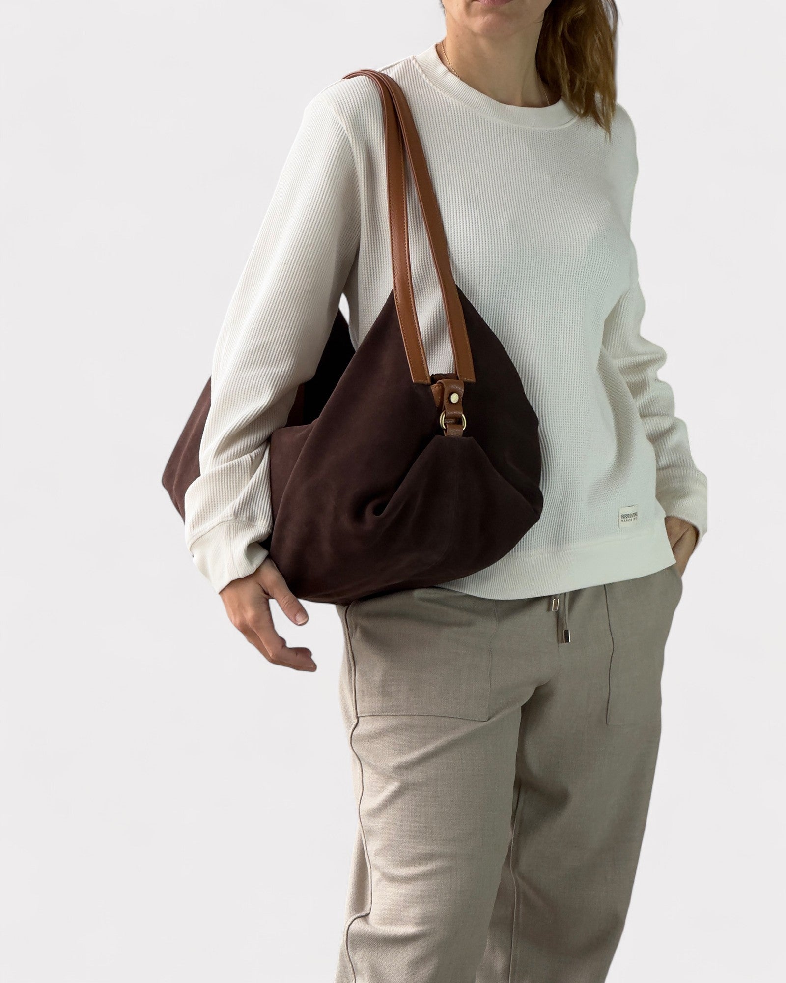 woman wearing dark brown suede handbag deluna
