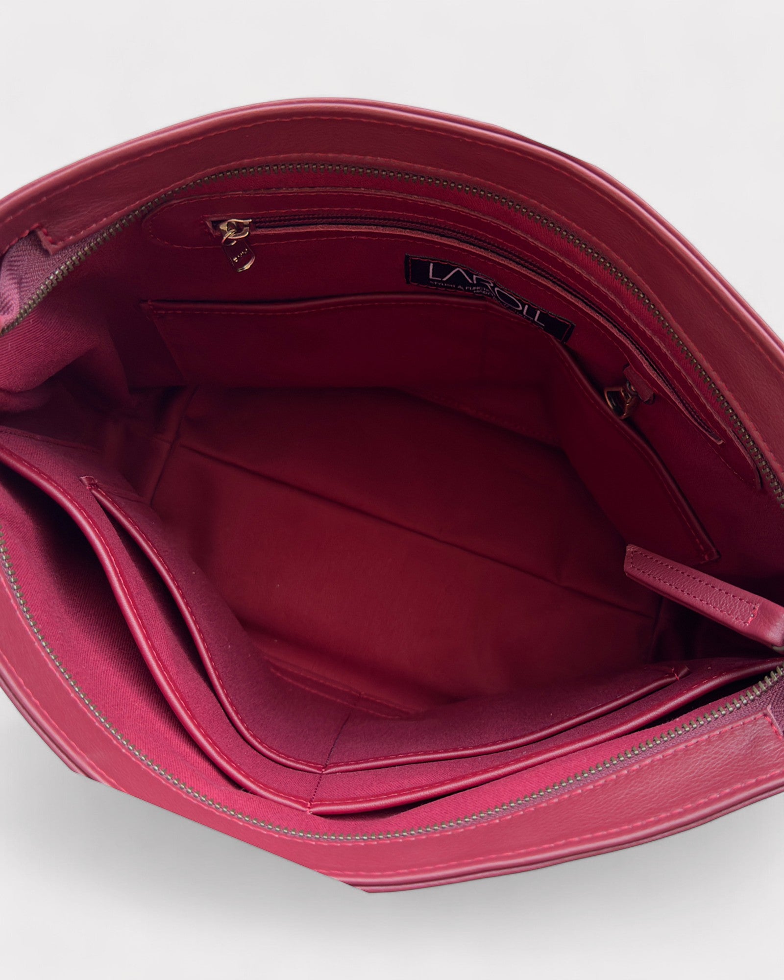 Close-up of a red handbag with visible brand logo on a white background