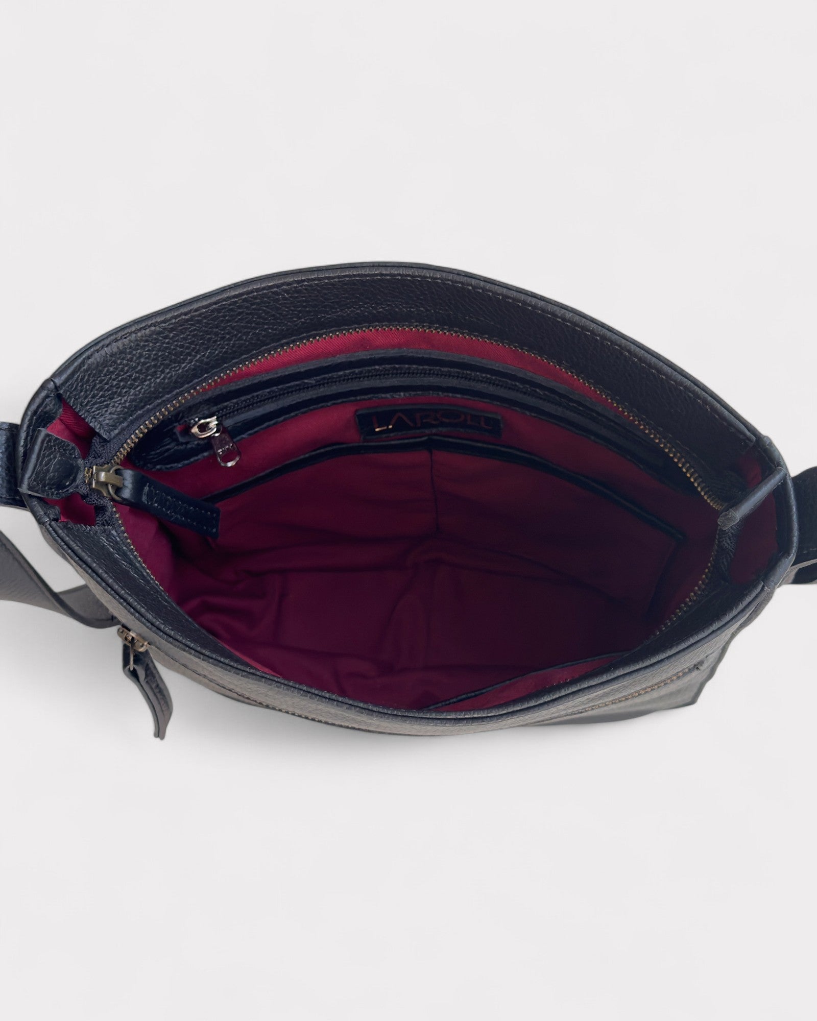 Black leather handbag with red interior on a white background