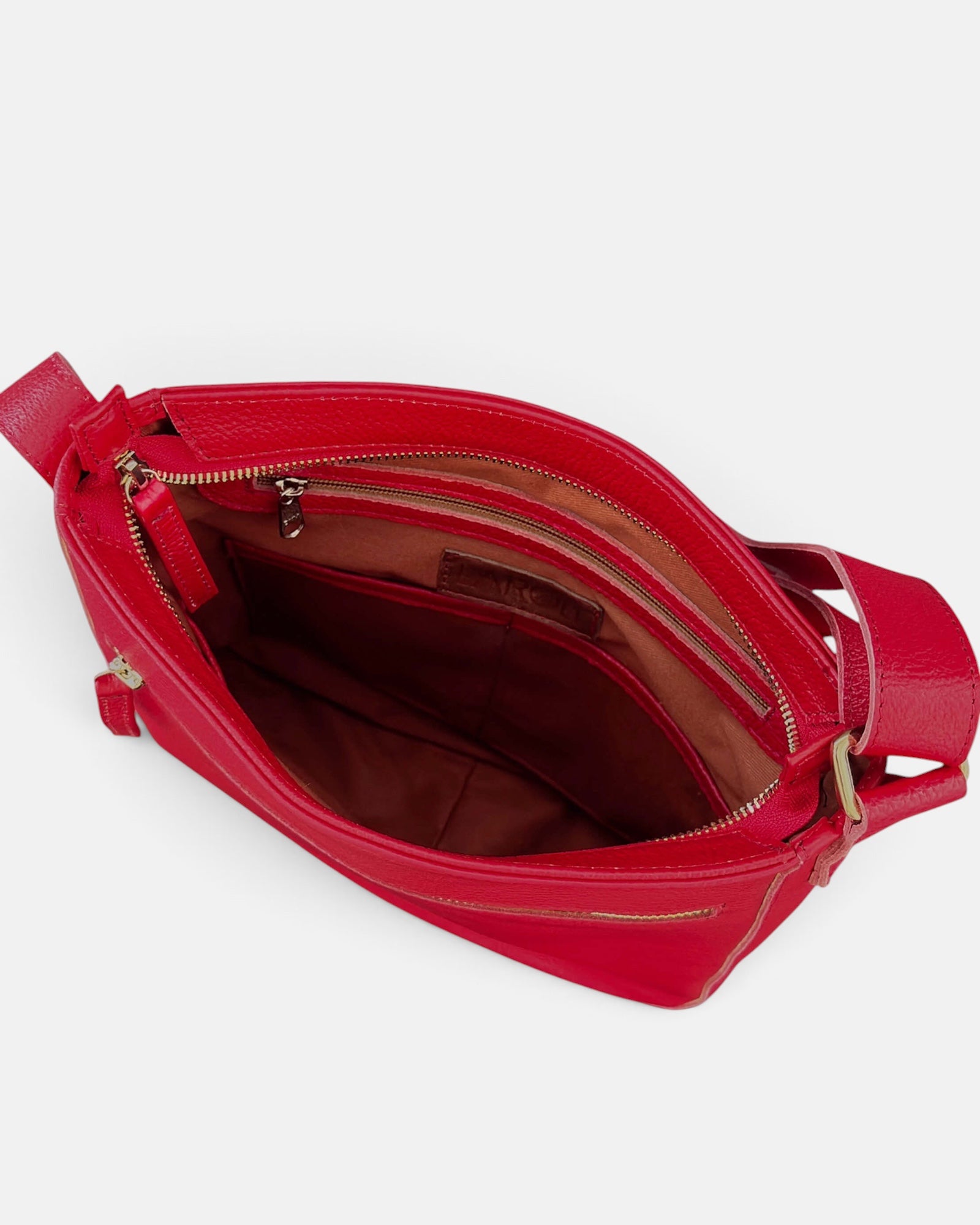 An open red leather crossbody bag with a gold-tone zipper and a brown interior lining, shown from a top-down angle on a light gray background.
