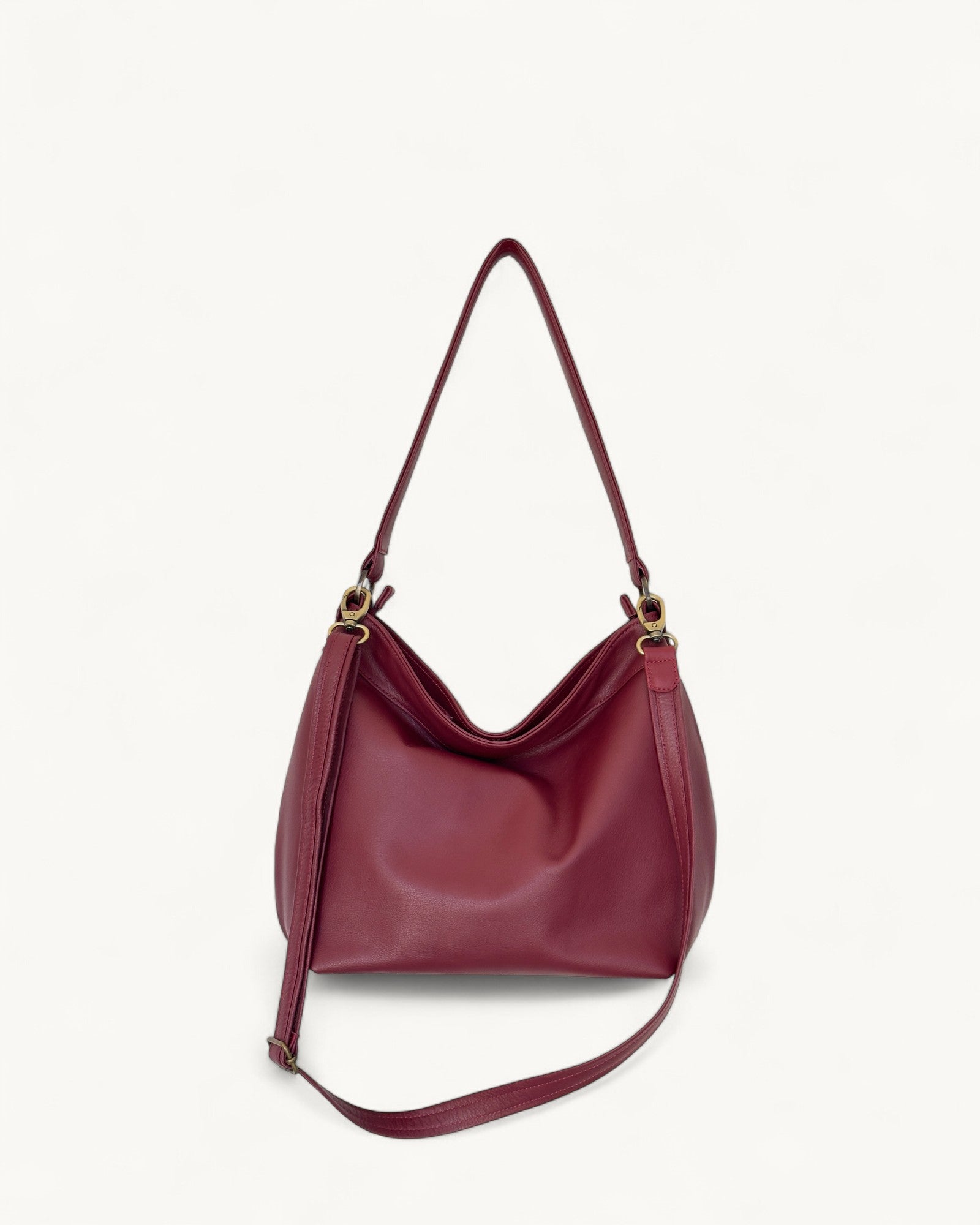 Red handbag with a strap on a light beige background