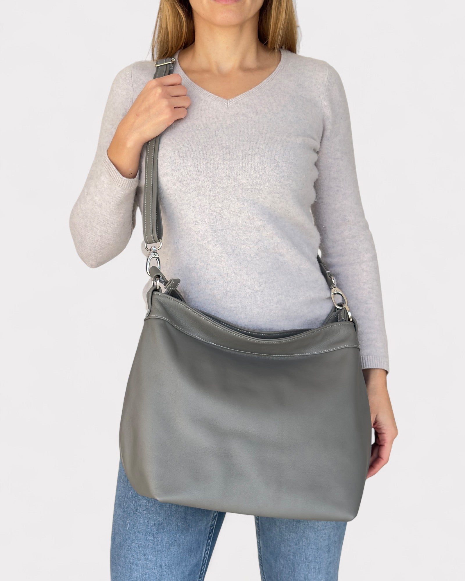 Person wearing a gray shoulder bag on a white background
