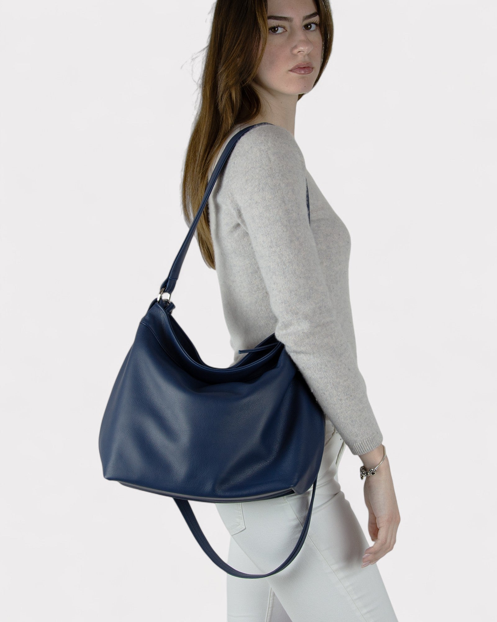 Woman carrying a navy blue handbag on a white background