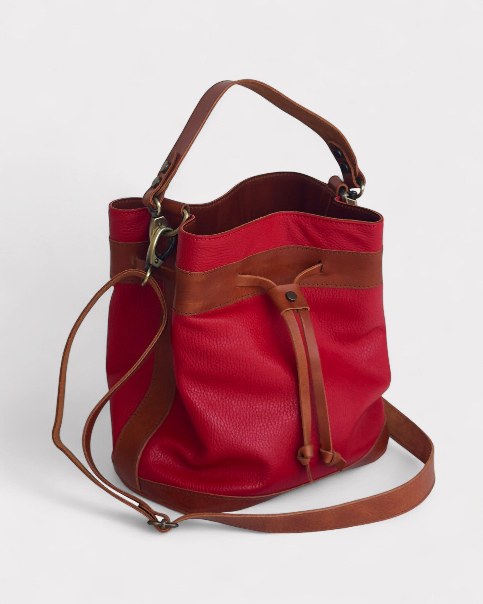 Red bucket with brown leather accents on a white background