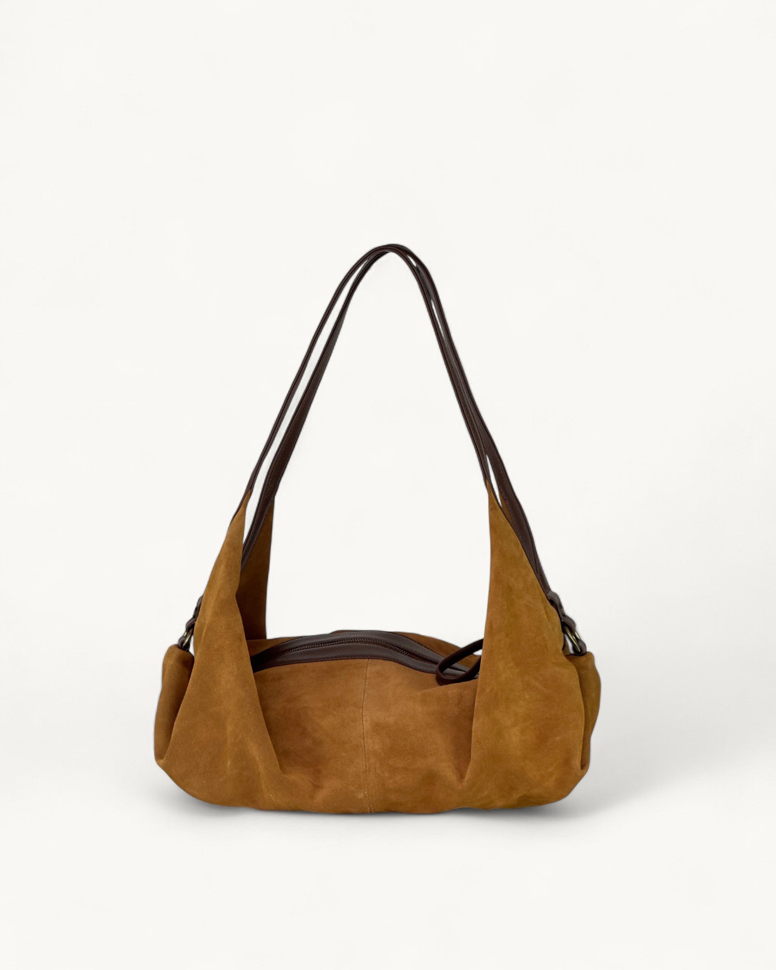 Tan handbag with a black strap on a white background