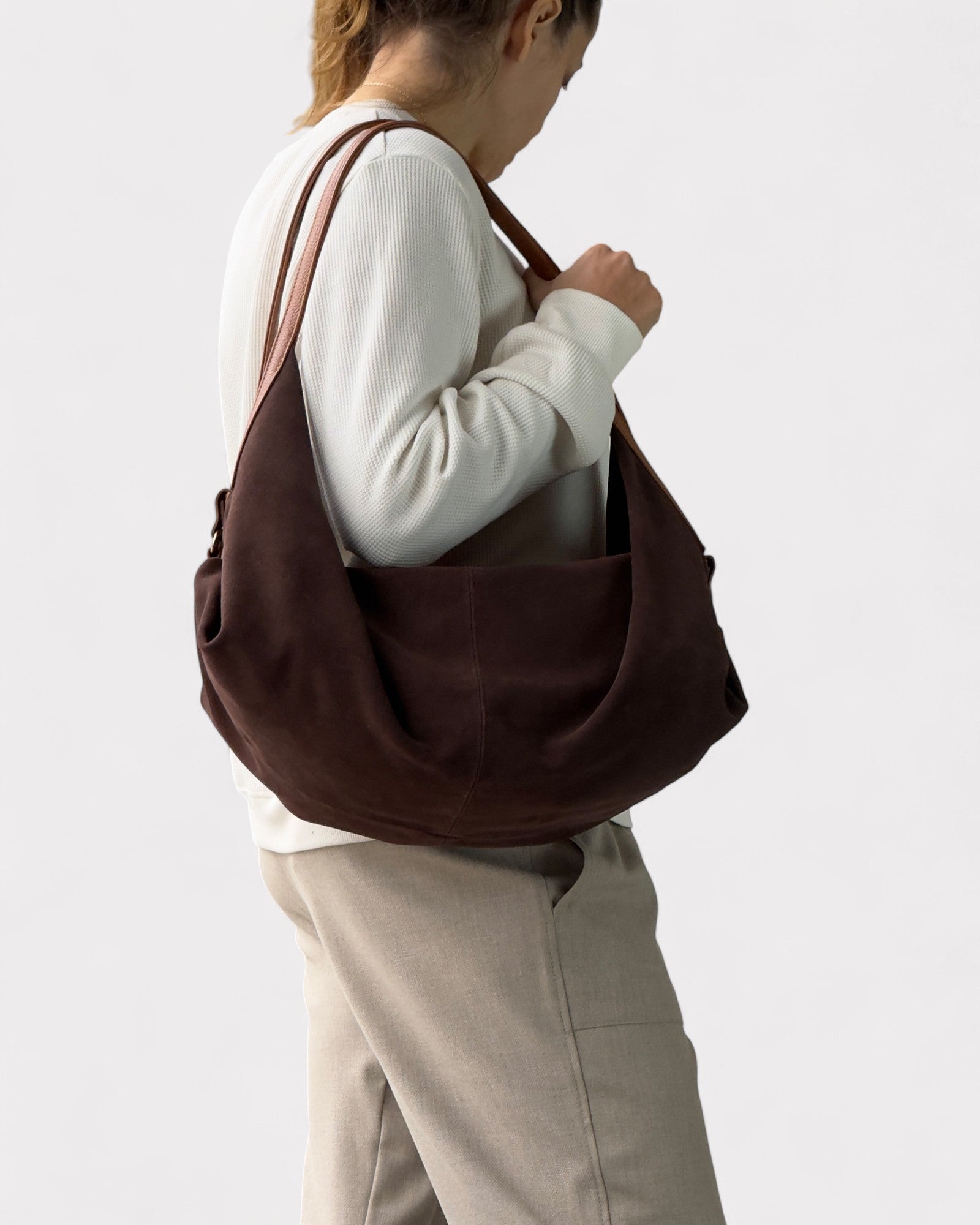 model wearing dark brown suede handbag deluna